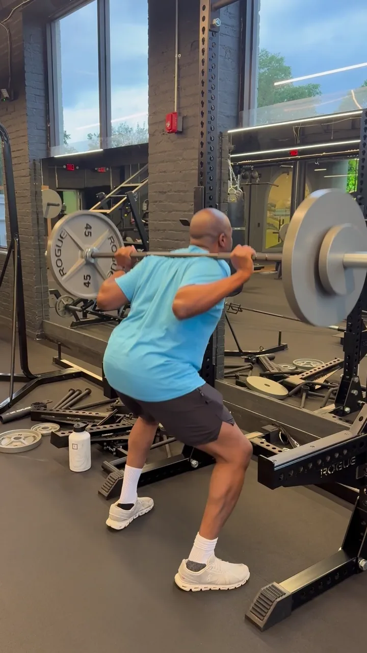 Barbell split squat in an on-site fitness room during a corporate strength session