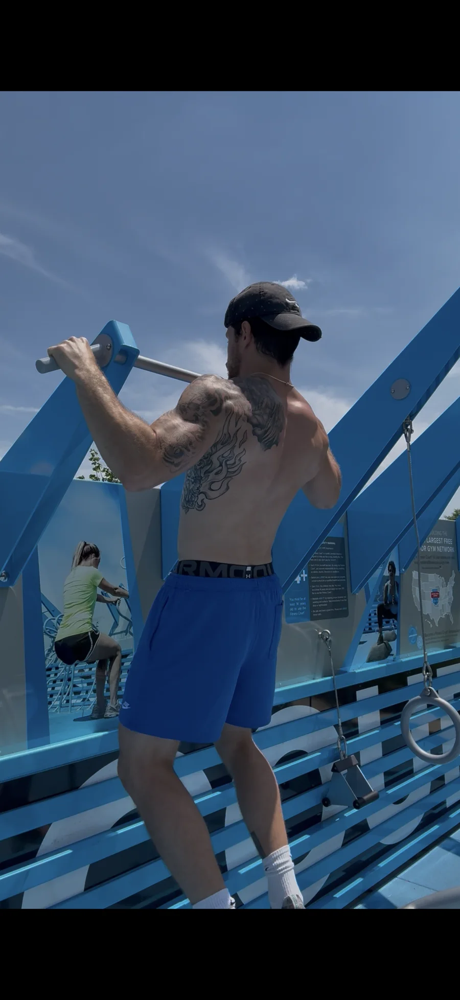 Pull-up on an outdoor bar structure during an outdoor strength session